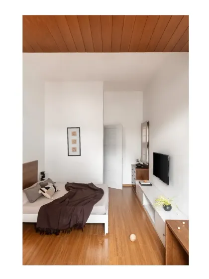 This guest room is designed with a Zen-like simplicity, featuring clean lines, a minimal color palette, and warm wooden floors.