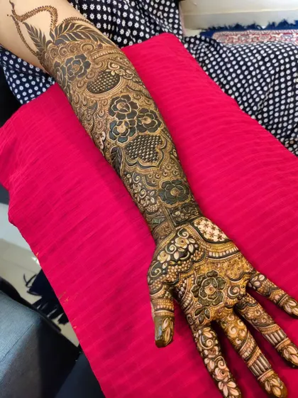 The full arm is covered in a beautiful tapestry of henna, a classic look for any bride.