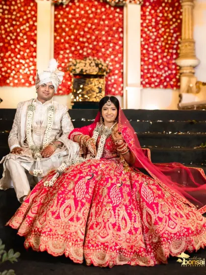 The couple seated on their wedding stage, looking regal and happy.