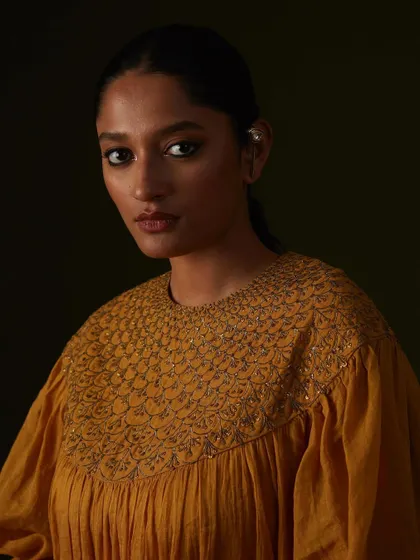 The rich texture of the embroidery on this mustard yellow top is the hero of this portrait.