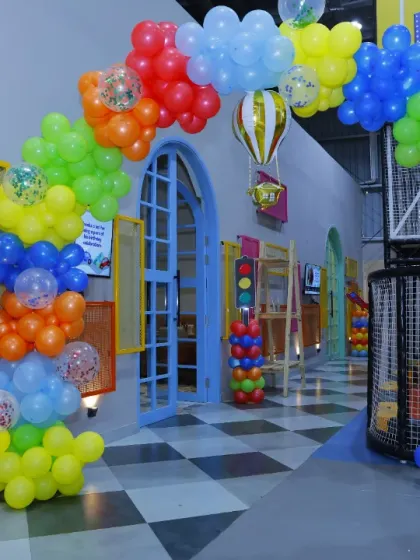 A vibrant, rainbow-colored balloon arch for a fun and cheerful birthday party entrance.