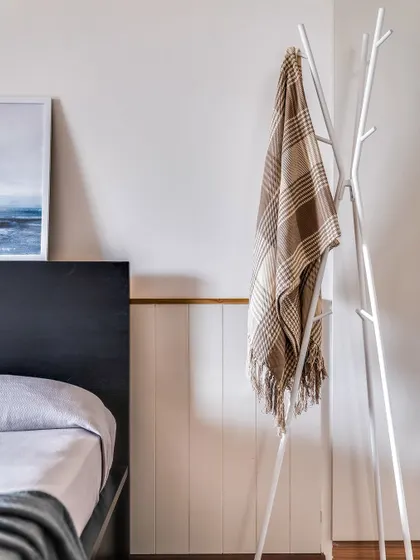 Even small details matter for storage. A simple, tree-like coat rack provides a convenient spot for guests to hang their belongings.