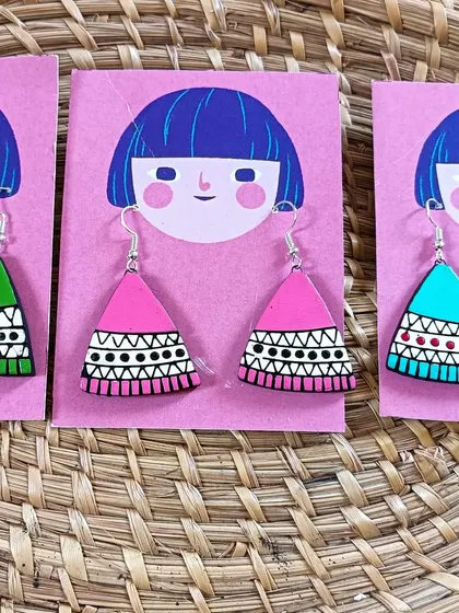 These triangular earrings feature intricate black and white patterns, available in bright pink, green, and blue. They are a great example of modern tribal design.