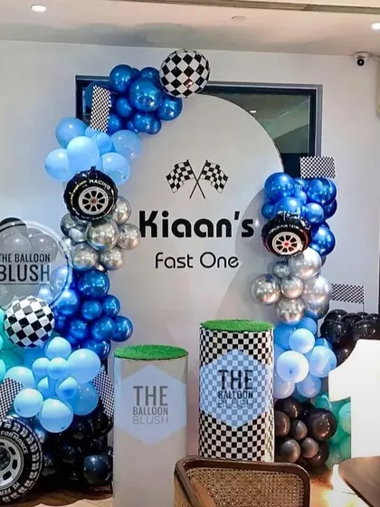 A "Fast One" racing theme for a first birthday. This modern setup uses shades of blue and silver, with tire and checkered flag details for a little racer.