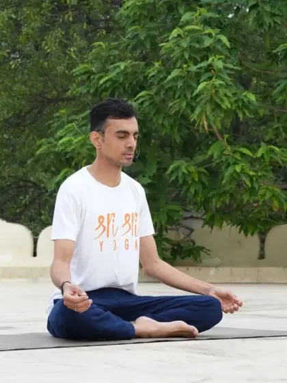 A young man sits in Padmasana (Lotus Pose) for meditation on a rooftop, surrounded by the lush greenery of the campus. There are countless quiet spots here to connect with yourself.