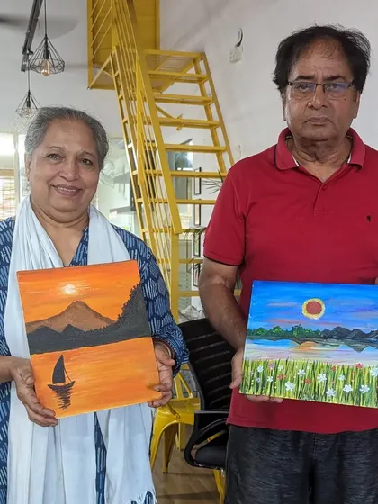 An adorable couple, our senior participants, proudly showing their finished canvas paintings. Art truly has no age limit!