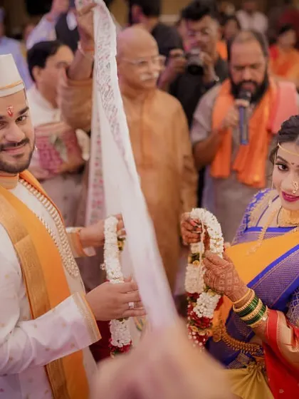 The moment the Antarpat is lowered, the bride and groom see each other and prepare to exchange garlands.