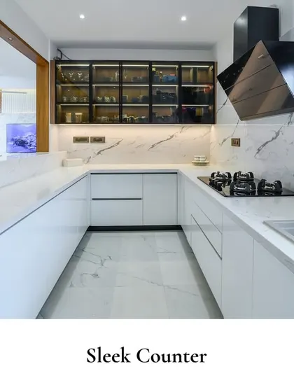 This kitchen reflects a modern aesthetic with a focus on minimalism and functionality, featuring clean white surfaces and an open pass-through to the living area.