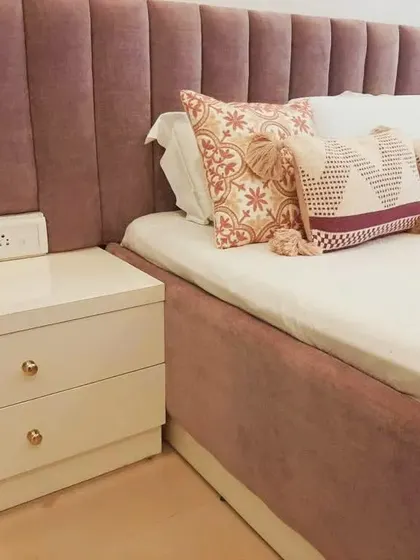 The details make the design. This close-up shows a custom-upholstered channel headboard in a soft pink fabric, paired with a sleek, handle-less side table, showcasing my commitment to high-quality finishing in every piece of furniture.