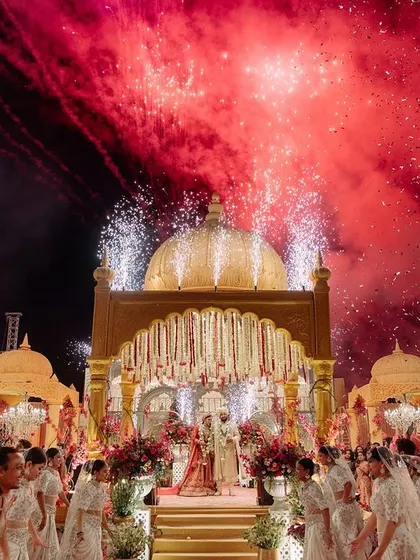 Here, a hillside venue becomes a royal stage with my 'Shahi Jharokha' design. As fireworks illuminate the sky, the golden domes and intricate architecture evoke the opulence of Udaipur's palaces, creating a moment of pure, breathtaking magic for the couple's grand entrance.