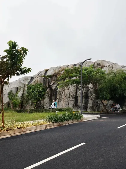 In this project, we chose to preserve and feature a magnificent natural rock outcropping, designing the community road to curve around it. This demonstrates our core belief in integrating the built environment with the existing landscape, making nature the centerpiece.