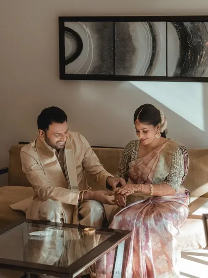A sweet, candid moment of the couple sharing a quiet interaction on a sofa. The warm sunlight streaming in adds a beautiful, natural glow.