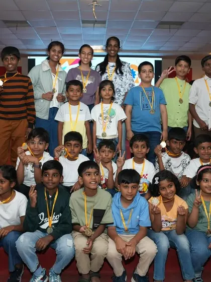 A large, happy group of participants and medalists on stage.