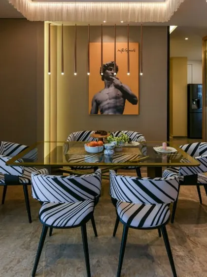 In the Clifton House project, the dining area carries the home's bold color story with a unique twist. The showstopper table features a veneer base with intersecting gold metal bars, paired with patterned chairs for a touch of personality.
