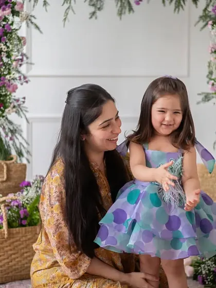 A heartwarming moment between a mother and her daughter during a brand photoshoot. The floral backdrop and their joyful expressions create a perfect lifestyle image that celebrates their bond.