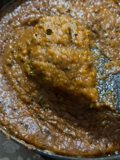 A spatula lifting some of the freshly made Puliogare paste. This ready-to-use mix makes it easy to prepare authentic temple-style tamarind rice at home.
