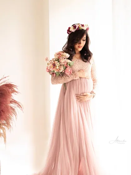 A beautiful, light-filled portrait. The mom-to-be holds a bouquet of flowers, and the floral crown completes this soft, bohemian-inspired look.
