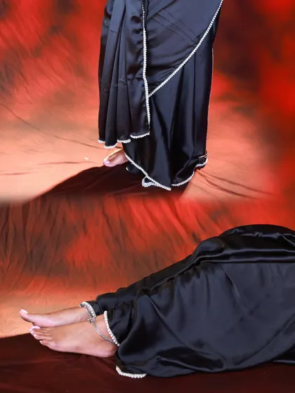 An abstract, artistic shot combining two different poses. It focuses on the details of the black saree, the pearl border, and the model's feet.