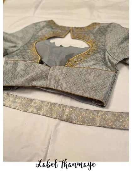 The blouse comes with a matching belt piece made from the same brocade fabric.