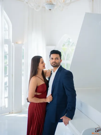 A stylish and classic pose by the white piano. This setup is perfect for couples looking for elegant and timeless pre-wedding photographs.