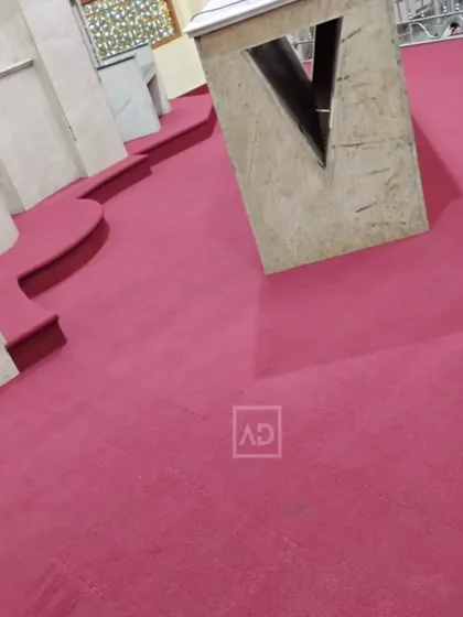 The carpet installed in a prayer hall, cut to fit around architectural features. The soft surface is comfortable for sitting or walking.