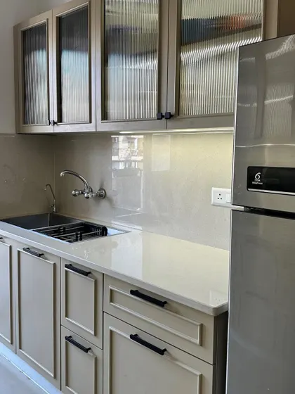 This angle shows the sink area and the seamless integration of the refrigerator into the custom cabinetry, creating a clean and organized look.