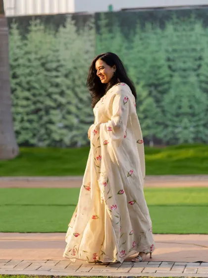 A candid walking shot at an outdoor corporate event. The elegant floral lehenga was perfect for the festive and celebratory atmosphere.