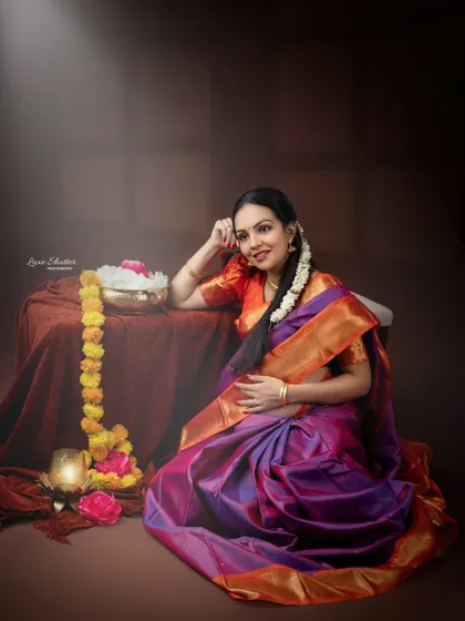 A classic portrait of a glowing mother-to-be in a traditional silk saree. The soft lighting and warm tones create a feeling of peace and contentment.
