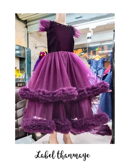 A wine-colored gown with a velvet bodice and a tiered, ruffled tulle skirt.