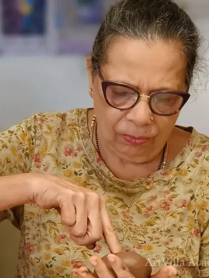 A participant at the Doolally workshop shapes her clay with care. The tactile process of hand-building is both meditative and rewarding.