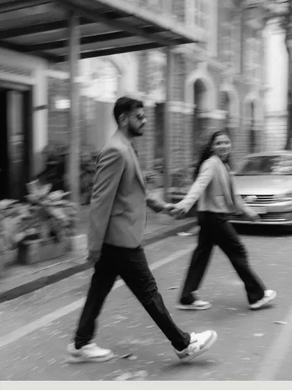A black and white motion-blur shot of a couple crossing a street, holding hands. This artistic technique adds a sense of movement and captures the bustling energy of the city.