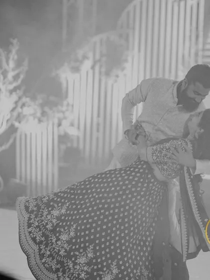 A dramatic black and white photo of a couple's romantic dance dip during their Sangeet.
