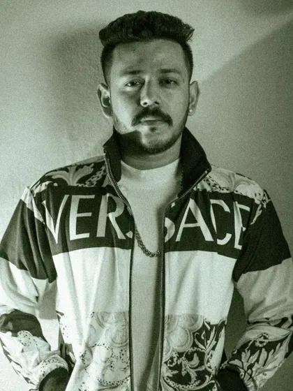 A black and white portrait with a gritty, high-contrast look. This edit emphasizes the model's direct gaze and the bold branding on his jacket, creating a powerful and modern fashion image.