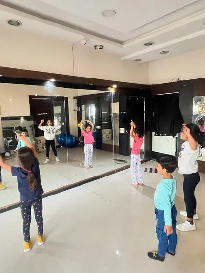 A group of young students learning choreography in front of the studio mirror. Watching their reflection helps them understand posture and movement, which is a key part of my teaching method.
