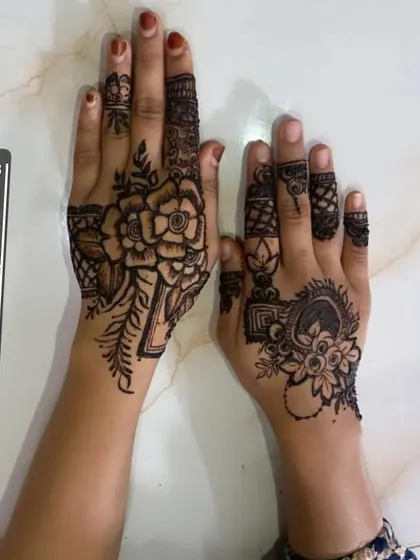 Mismatched designs for a fun and modern look. One hand features a bold rose, while the other has a more traditional floral mandala, showing how you can play with different styles.