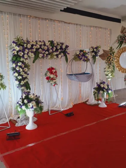 This setup features a full floral arch made of white and purple flowers, creating a beautiful frame for the ceremony.