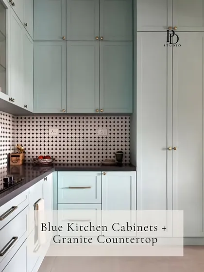 This kitchen showcases a beautiful pairing of soft blue cabinets with a durable granite countertop. The classic shaker-style doors and patterned tile backsplash add a touch of timeless charm and personality.