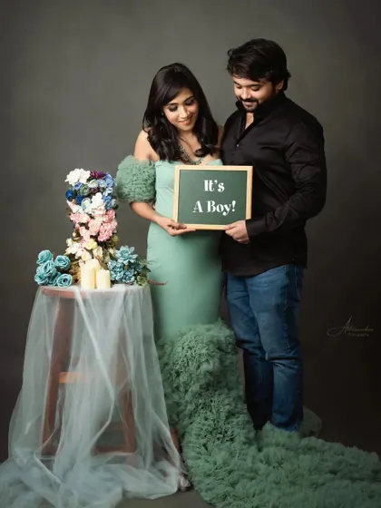Announcing "It's a Boy!" This couple's portrait in our studio uses a chalkboard sign and a beautiful floral setup to share their happy news.