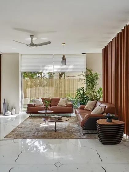 The foyer at Kanasu, where a wooden screen provides privacy while allowing glimpses into the open living area, setting a warm and inviting tone.