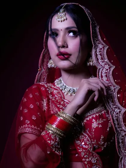 A dramatic, fashion-inspired bridal portrait. The pose and lighting are designed to convey a powerful, almost cinematic mood, showcasing a different, more intense side of bridal photography.