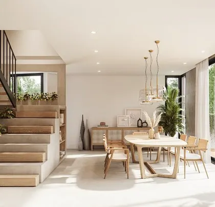 Another view of the open-plan living and dining area in a Kolgaon villa. The space is organized around a concrete staircase with built-in planters, which acts as a multi-functional element that merges furniture, landscape, and architecture.