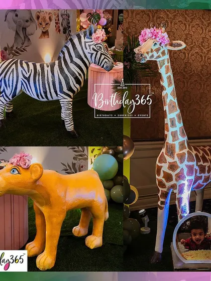 A close-up of the life-sized animal props from our jungle theme, including a zebra, lioness, and giraffe, all adorned with pretty pink flower crowns.