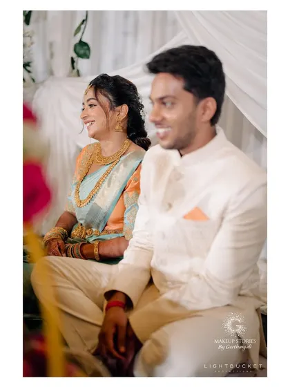 A happy, candid moment from Harshitha's engagement ceremony. Her makeup looks fresh and natural, capturing her radiant smile and the joy of the occasion.