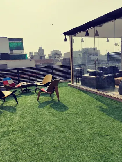 The perfect blend of indoor comfort and outdoor freedom. This project features a spacious artificial lawn with modern furniture right outside the prefab glass room.