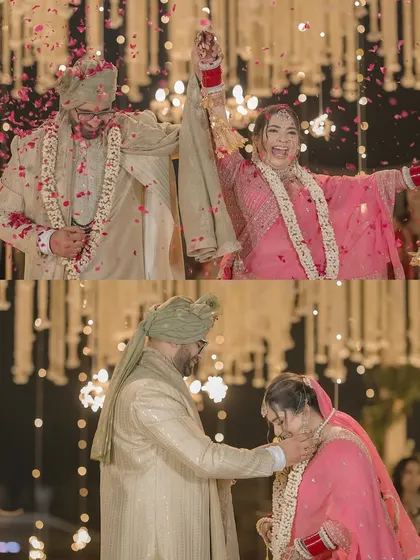 The triumphant moment after the Varmala exchange, with the couple celebrating under a shower of flower petals at their nighttime ceremony.