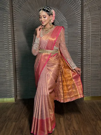 The full view of the pink Kanchivaram, showing the beautiful fall of the saree and the perfectly arranged pleats. The kamarbandh accentuates the waist.