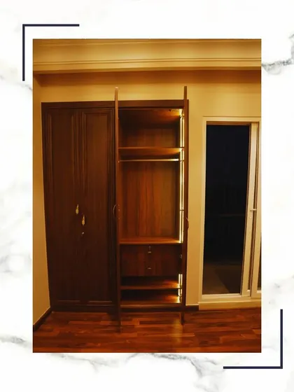 Step into sophistication with our bespoke closets. This image shows a rich, dark wood wardrobe that offers ample storage while adding a touch of class to the bedroom.