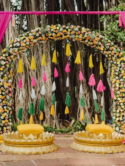 This Haldi was a carnival of colors. A vibrant floral arch and a backdrop of colorful tassels created a joyful, high-energy space for the couple to be showered with love and blessings.