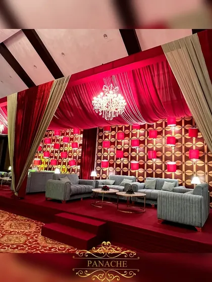 A luxurious lounge area for the after-party, created with rich red velvet drapes, modern sage green sofas, and crystal chandeliers.
