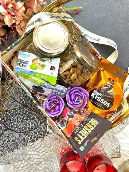 This is my "All in One" Diwali hamper. It's packed with a variety of treats including dry fruit jars, chocolates, and festive candles, making it a truly impressive gift.